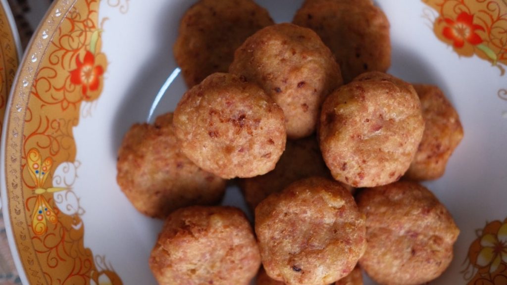 a white plate topped with meatballs on top of a table